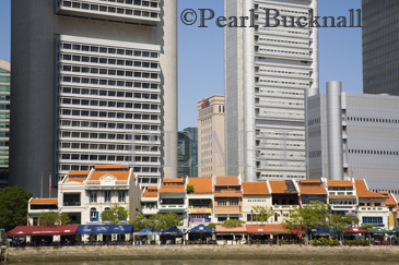 Boat Quay Conservation Area bars and restaurants in 
colourful historic old shophouse buildings on south 
bank of River with towering new skyscrapers of Raffles 
Place Singapore Asia

