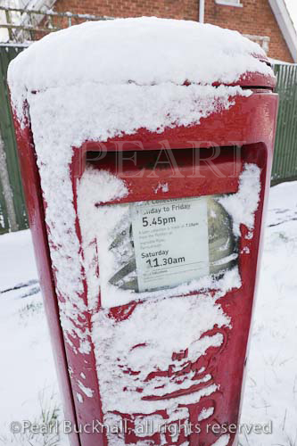 Red postbox covered in snow. Britain, UK, Europe. 

Keywords: royal mail post box mailbox winter