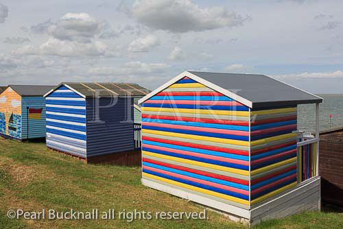 Colourful wooden beach huts overlooking the Thames 
estuary on the north Kent coast. Tankerton, Whitstable, 
Kent, England, UK, Britain