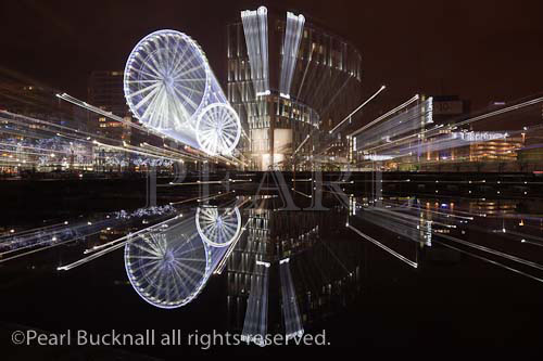 Liverpool Wheel and waterfront reflections zoomed 
across Salthouse Dock at night. Liverpool, Merseyside, 
England, UK, Europe.

Keywords: city, nightlife, lights,