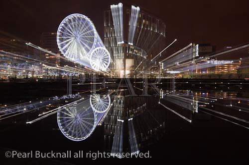 Liverpool Wheel and waterfront reflections zoomed 
across Salthouse Dock at night. Liverpool, Merseyside, 
England, UK, Europe.

Keywords: city, nightlife, lights,