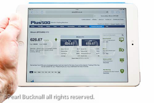 Person holding an iPad mini tablet whilst looking at
Plus500 website quoting Bitcoin exchange rate and
trading prices in USD isolated on white background.
MR 14/04