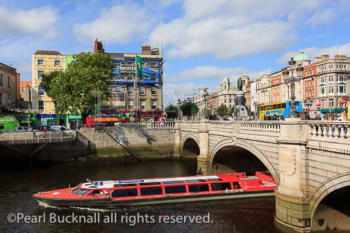 Sightseeing cruise boat passing under the O'Connell 
Bridge on the River Liffey. Aston Quay, Dublin, 
Republic of Ireland, Eire, Europe. 