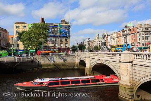Sightseeing cruise boat passing under the O'Connell 
Bridge on the River Liffey. Aston Quay, Dublin, 
Republic of Ireland, Eire, Europe. 