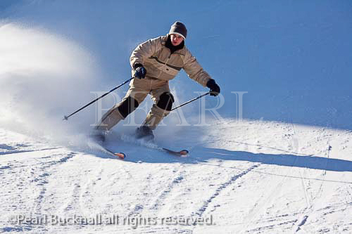 Alpine skier skiing fast downhill on snow slopes in 
Austria Europe. 