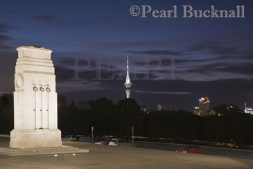 World War memorial cenotaph Court of Honour outside 
museum building floodlit at night in Auckland Domain 
with Skytower in dark sky Auckland North Island New 
Zealand 

