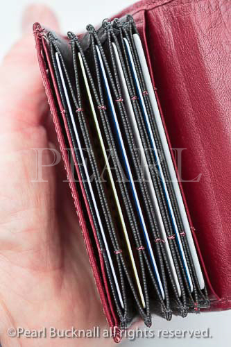 Woman's hand holding a red leather card holder 
containing bank cards. MR 14/05