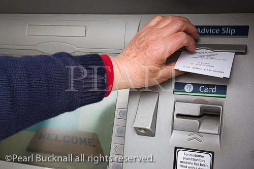 Hole in the Wall ATM cashpoint machine welcome 
screen with lady's hand removing advice slip receipt. 
England UK Britain  MR 07/3
