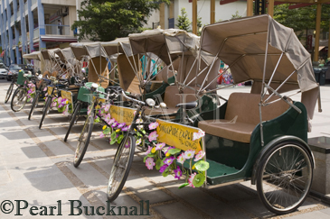 Row of rickshaw tricycles parked on street for tourist 
sightseeing tours. Chinatown Singapore Asia

