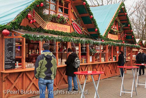Customers at a Christmas market stall selling drinks 
and traditional Gluhwein in Alexanderplatz, Berlin, 
Germany, Europe. 