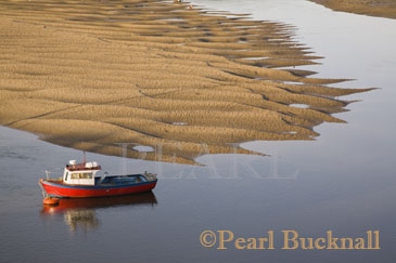Red boat by exposed sandbank on Conwy River 
estuary at low tide. Conwy North Wales UK Britain

Keywords: boat coast water Welsh Britain British
