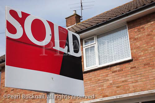 Estate Agent's sold sign outside a house in England 
UK 
Britain