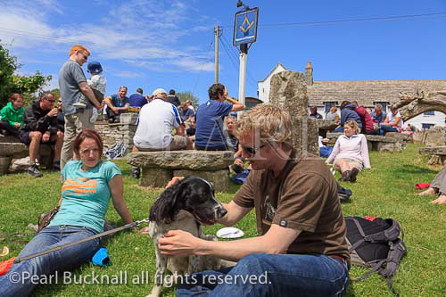 Scene with people sitting in busy beer garden of the 
Square and Compass country village pub in summer. 
Worth Matravers, Dorset, England, UK, Britain.
