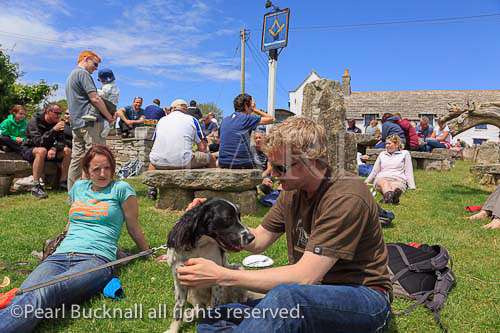 Scene with people sitting in busy beer garden of the 
Square and Compass country village pub in summer. 
Worth Matravers, Dorset, England, UK, Britain.