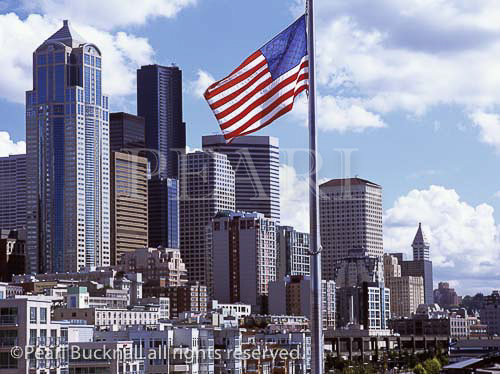 Downtown skyline from Pier 66 with the Stars and 
Stripes flag and city buildings. Seattle Washington 
State USA North America. 