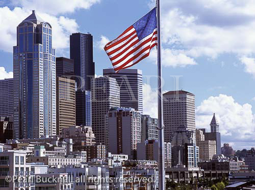 Downtown skyline from Pier 66 with the Stars and
Stripes flag and city buildings. Seattle Washington
State USA North America.