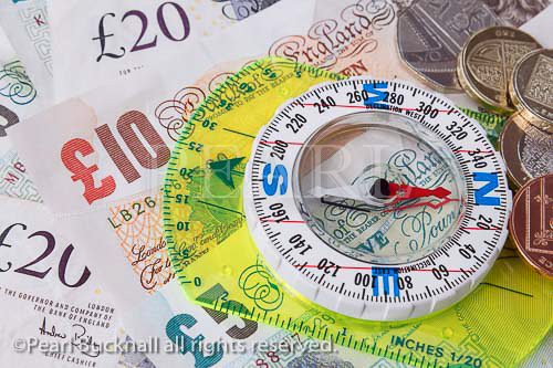 Compass on sterling money notes to illustrate the 
direction of the British economy concept. England, 
UK, Britain, Europe