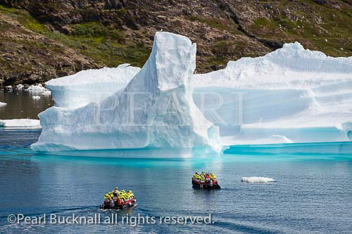 Tourists sailing in small boats close to large Icebergs 
from Tunulliarfik fjord in summer. Narsaq, Kujalleq, 
South Greenland