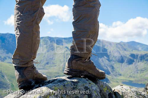Hiker wearing hiking boots standing on Pen yr Ole 
Wen with Mount Snowdon in distance in Snowdonia 
National Park. Ogwen, Conwy, North Wales, UK, 
Britain, Europe. MR 15/15