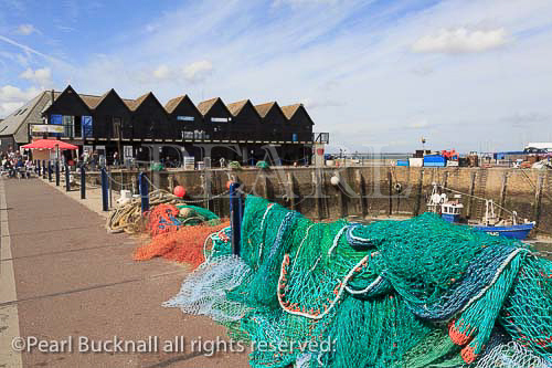 Harbour scene with colourful fishing nets on the quay 
on north Kent coast and Thames estuary in Whitstable, 
Kent, England, UK, Britain, Europe. 