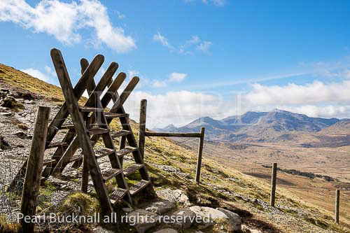Two stiles on path from Moel Siabod to Capel Curig 
with view to Mount Snowdon Horseshoe in mountains 
of Snowdonia National Park. Capel Curig, Conwy, 
North Wales, UK, Britain.