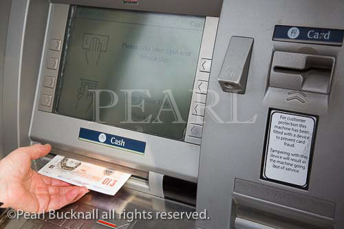 Chester Cheshire England UK / Hole in the Wall ATM 
cashpoint machine remove money screen with lady's 
hand removing notes from slot  MR 07/3