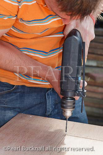 Man drilling into wood with an electric power drill 
power tool. England UK Britain  