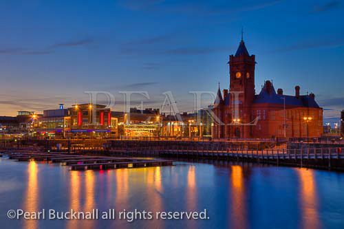 Cardiff Bay (Bae Caerdydd), South Wales, UK. View 
across water to Pierhead building and waterfront at 
dusk

coast coastline city buildings night reflections sea 
water