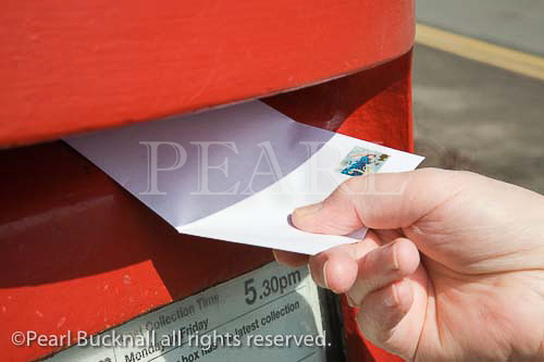 Close view of person's hand holding letter with 2nd 
class stamp to post in red postbox. UK Britain MR 
08/07