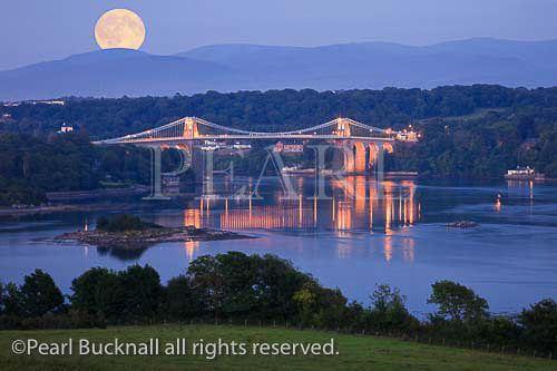 Full moon rising over the Menai Strait with the Menai 
suspension bridge illuminated at night. Menai Bridge 
(Porthaethwy), Isle of Anglesey (Ynys Mon), North 
Wales, UK, Britain