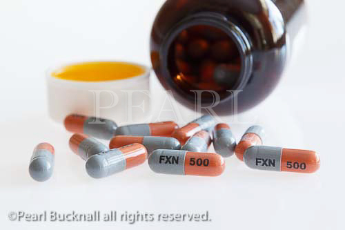 Pill bottle with Flucloxacillin 500 mg oral antibiotic 
capsules containing penicillin for treating bacterial 
infections, on a white background.