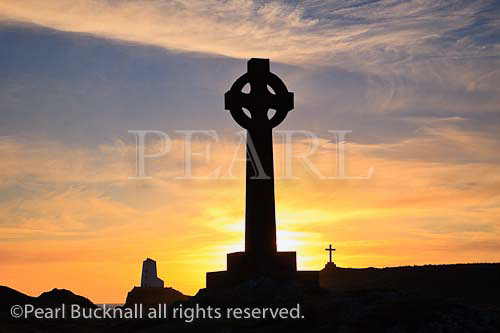 Celtic cross and Twr Mawr lighthouse in silhouette on 
Llanddwyn Island at sunset. Newborough, Isle of 
Anglesey, North Wales, UK, Europe

Keywords: setting sun sky Britain British Welsh 
heritage Ynys Mon