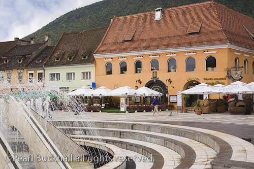 Brasov Transylvania Romania Europe / Fountain in 
pedestrianised Council Square Piata Sfatului with 
pavement cafes in medieval city centre
