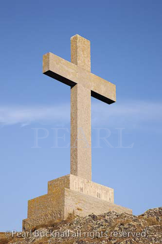 Stone cross of St Dwynwen Welsh patron saint of 
lovers. Llanddwyn Island, Newborough, Anglesey, 
North Wales, UK, Europe.

Keywords: crucifix blue sky