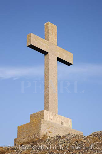 Stone cross of St Dwynwen Welsh patron saint of 
lovers. Llanddwyn Island, Newborough, Anglesey, 
North Wales, UK, Europe.

Keywords: crucifix blue sky