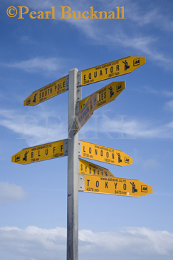 World directions and distances signpost against blue 
sky. Cape Reinga Northland North Island New Zealand

