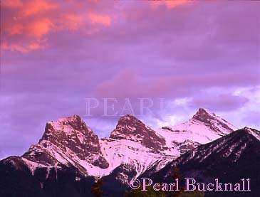 THREE SISTERS MOUNTAIN RANGE in the Rocky 
Mountains at sunset.  Canmore, Alberta, Canada.

Keywords: clouds scenic sky snow travel