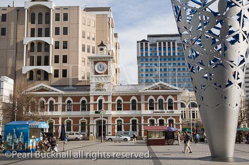Old Post Office clock tower in Cathedral Square in city 
centre with The Chalice modern steel sculpture by Neil 
Dawson. Christchurch Canterbury South Island New 
Zealand
