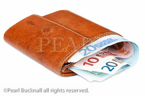Old leather purse stuffed with Euro notes isolated on a 
white background