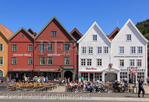 People in outdoor restaurants in historic wooden 
buildings on Bryggen, Bergen, Hordaland, Norway, 
Scandinavia, Europe. 