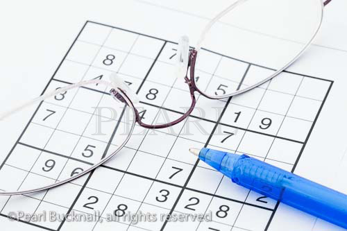 Suduko numbers game spectacles and pen close-up

