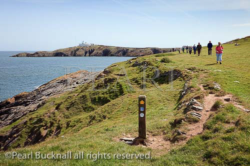 Isle of Anglesey Coastal Path with people walking from 
Point Lynas. Llaneilian, Isle of Anglesey, North Wales, 
UK, Europe. 

Keywords: Welsh coast walk walkers Britain British