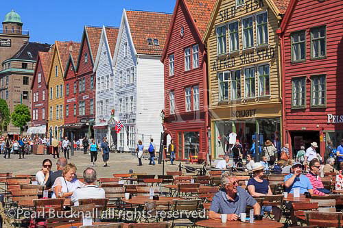 People dining in outdoor cafe in historic wooden 
buildings on Bryggen, Bergen, Hordaland, Norway, 
Scandinavia, Europe.