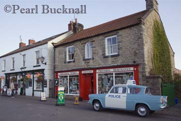 Aidensfield village shop with old Anglia police car 
parked as used in Heartbeat TV drama.  Goathland 
North Yorkshire Moors National Park England UK 
Europe

Keywords: tourism village filmset