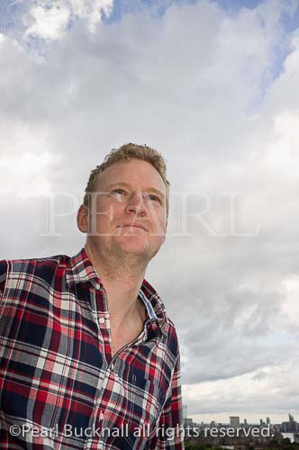 Young man wearing a check shirt portrait from a low 
angle. England, UK, Britain, Europe. MR 11/28
