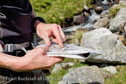 Hiker navigating with a map and compass in 
mountains of Snowdonia National Park. Ogwen, 
Conwy, North Wales, UK, Britain, Europe. MR 15/15