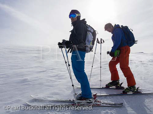 Two skiers on snow slopes backlit against the sun near 
Samoens, Haute Savoie, Rhone-Alpes, France, Europe. 