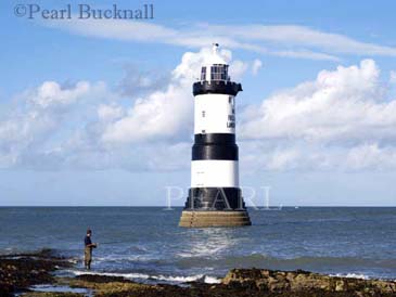 PENMON LIGHTHOUSE (1837) with a man fishing from 
rocks.  Penmon Point Anglesey North Wales UK

Keywords: activity coast heritage landmark scenic sea 

