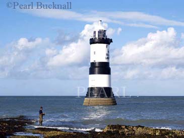 PENMON LIGHTHOUSE (1837) with a man fishing from 
rocks.  Penmon Point Anglesey North Wales UK

Keywords: activity coast heritage landmark scenic sea 

