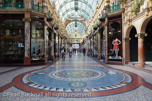 Floor mosaic and traditional upmarket designer shops 
in County Arcade in the Victoria Quarter shopping 
centre. Leeds, West Yorkshire, England, UK, Britain, 
Europe.